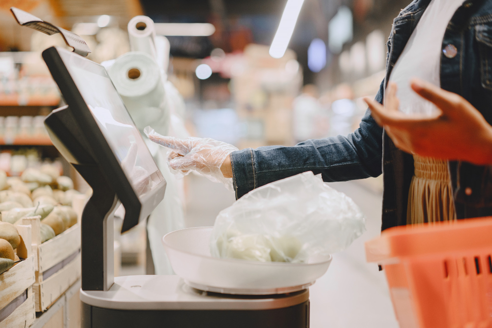 Cliente utilizando terminal de autoatendimento com balança no supermercado
