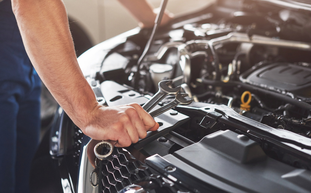 Mecânico com chaves de boca realizando reparo automotivo no motor de veículo