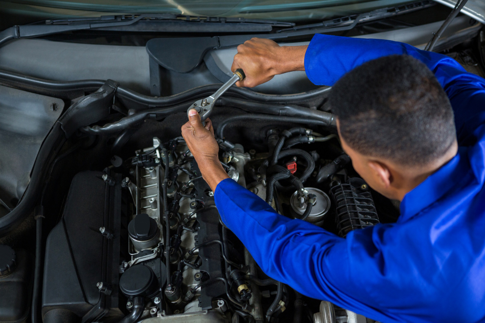 Mecânico realizando manutenção em motor de carro com ferramentas profissionais